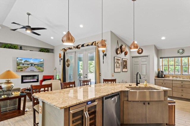 kitchen with stainless steel dishwasher, a sink, light wood finished floors, beverage cooler, and open floor plan