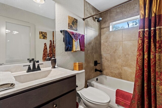 full bath featuring vanity, shower / tub combo with curtain, a textured wall, and toilet