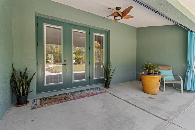 view of exterior entry with stucco siding and french doors