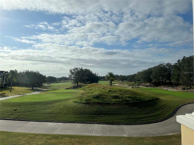 view of property's community featuring a yard and view of golf course