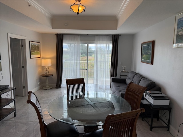 dining area featuring baseboards, crown molding, and a tray ceiling