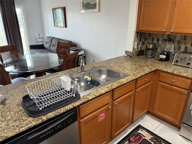 kitchen featuring decorative backsplash, stainless steel dishwasher, light stone countertops, a sink, and a peninsula