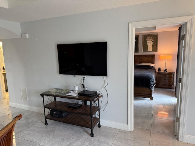 interior space with baseboards, arched walkways, and visible vents
