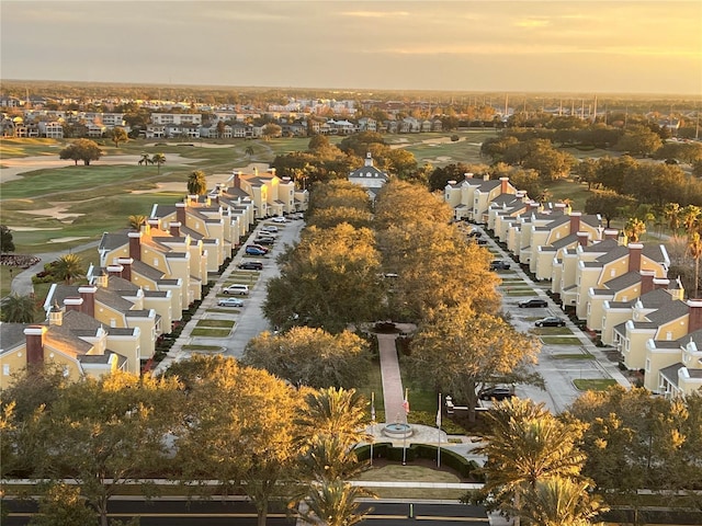 aerial view at dusk featuring a residential view and golf course view