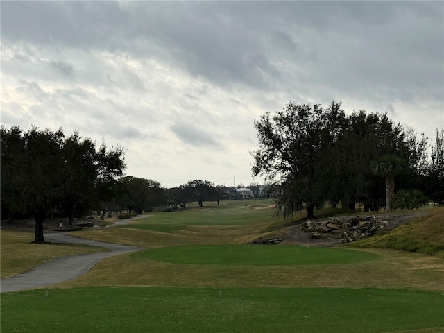 view of property's community featuring golf course view and a yard