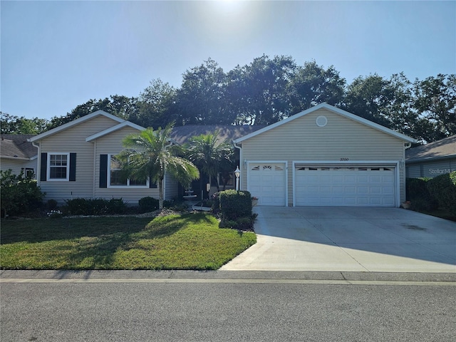 ranch-style home featuring a garage, a front yard, and concrete driveway