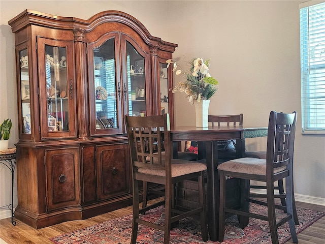 dining area with baseboards and wood finished floors