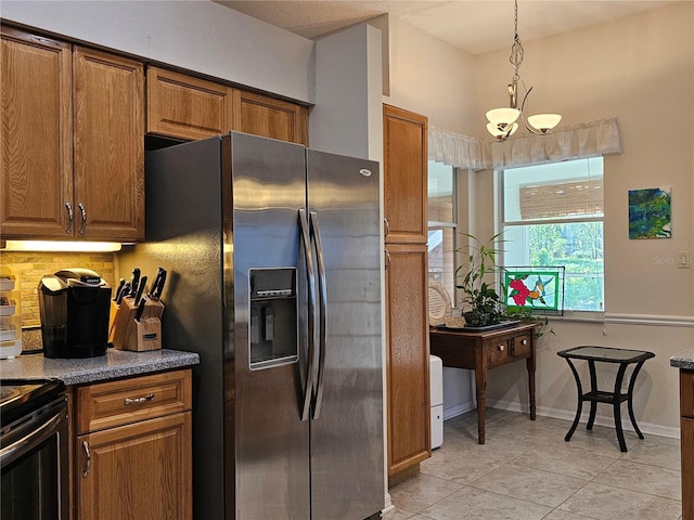 kitchen with light tile patterned floors, brown cabinets, stainless steel refrigerator with ice dispenser, and a chandelier