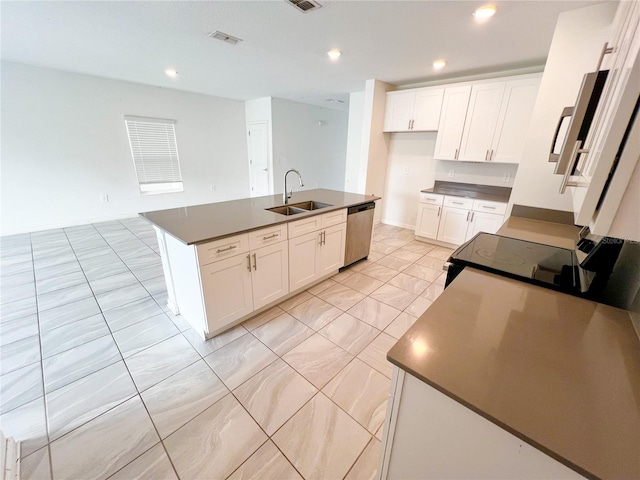 547 Jett Ln, Davenport, FL 33837 - kitchen with dishwasher, dark countertops, range with electric stovetop, white cabinetry, and a kitchen island with sink