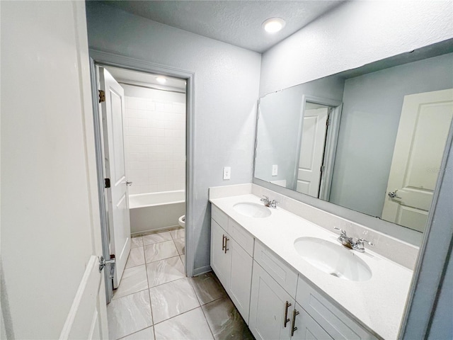 547 Jett Ln, Davenport, FL 33837 - bathroom featuring double vanity, marble look tile flooring, and a textured ceiling