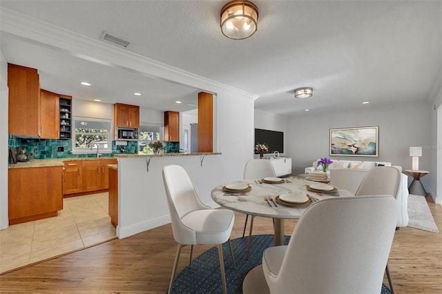 1231 Glastonberry Rd, Maitland, FL 32751 - dining room featuring light wood-type flooring, ornamental molding, visible vents, and recessed lighting