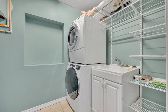 1231 Glastonberry Rd, Maitland, FL 32751 - laundry area featuring cabinet space, baseboards, stacked washing maching and dryer, and light tile patterned floors