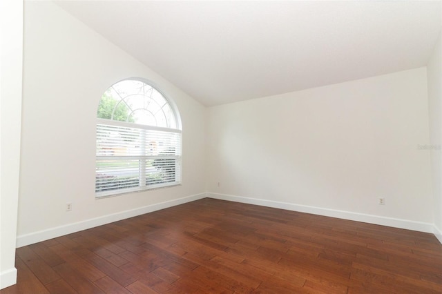 unfurnished room with baseboards, vaulted ceiling, and hardwood / wood-style floors