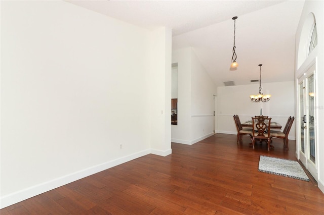dining area with baseboards, vaulted ceiling, and wood finished floors