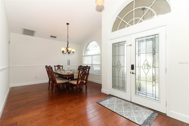 foyer with a notable chandelier, hardwood / wood-style floors, baseboards, vaulted ceiling, and visible vents
