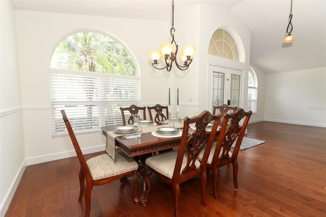 dining space with baseboards, an inviting chandelier, vaulted ceiling, and hardwood / wood-style floors
