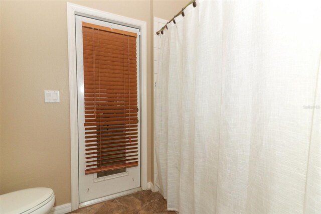 bathroom with toilet and baseboards