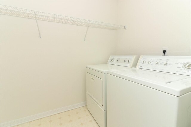 clothes washing area featuring light floors, baseboards, laundry area, and washer and dryer