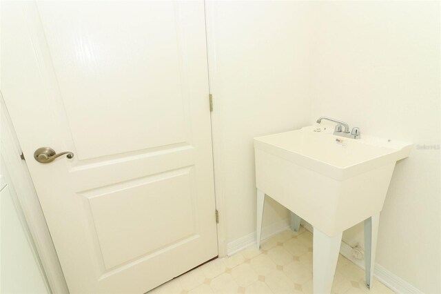 bathroom featuring baseboards and a sink