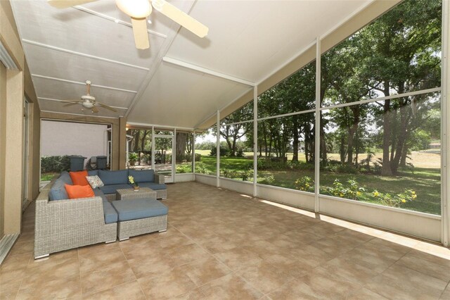 sunroom featuring a ceiling fan and an outdoor living space