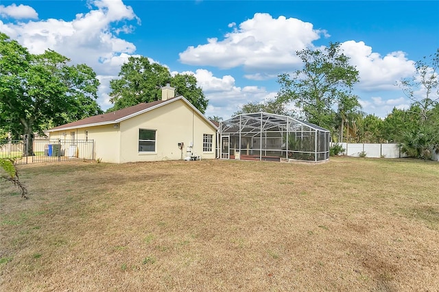 1512 Adriatic Dr, Ocoee, FL 34761 - rear view of property with a lanai, a chimney, a fenced backyard, a yard, and stucco siding