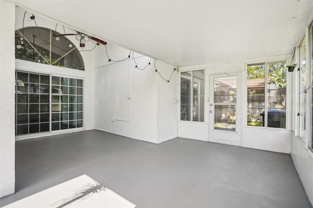 unfurnished sunroom featuring ceiling fan