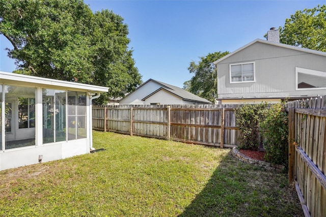 view of yard with a fenced backyard and a sunroom