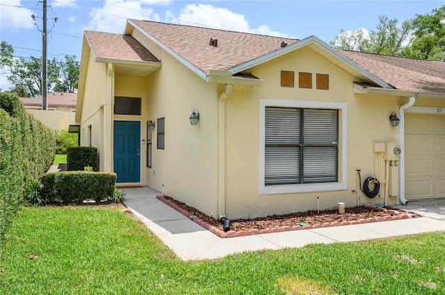 ranch-style house with an attached garage, a front lawn, roof with shingles, and stucco siding