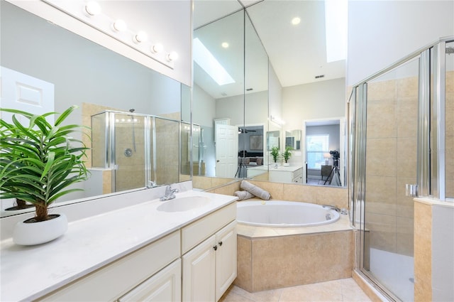 full bathroom with a bath, a skylight, tile patterned flooring, a stall shower, and vanity