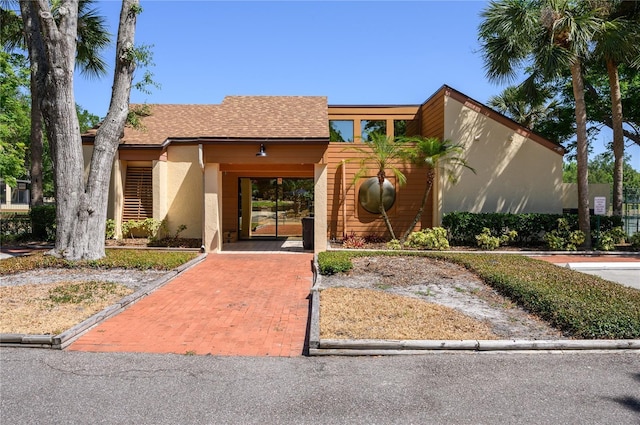 view of front of property with roof with shingles and stucco siding