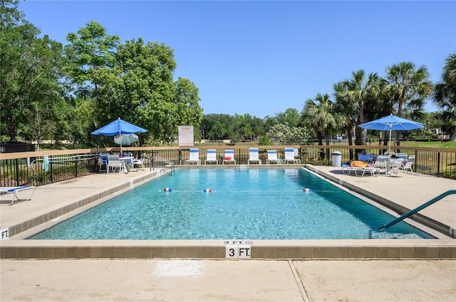 pool with a patio and fence