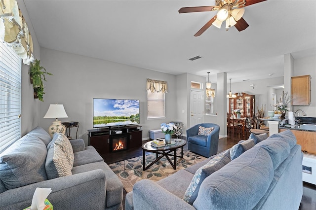 3917 Pemberly Pines Cir, Saint Cloud, FL 34769 - living room with a glass covered fireplace, ceiling fan, dark wood-style floors, and visible vents