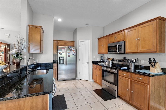 3917 Pemberly Pines Cir, Saint Cloud, FL 34769 - kitchen featuring a sink, light tile patterned floors, brown cabinets, and stainless steel appliances