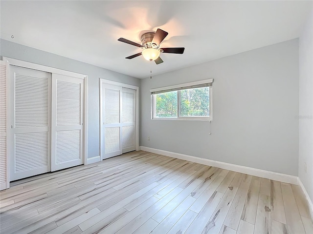 2631 Mcdonald Ter, Mount Dora, FL 32757 - unfurnished bedroom with light wood-style floors, multiple closets, baseboards, and a ceiling fan