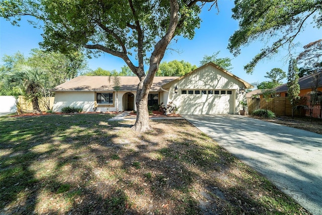 ranch-style house featuring concrete driveway, stucco siding, fence, and a garage