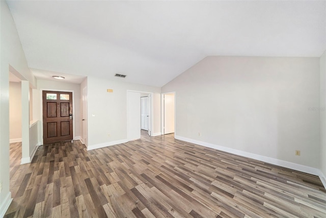 unfurnished living room with baseboards, visible vents, wood finished floors, and lofted ceiling