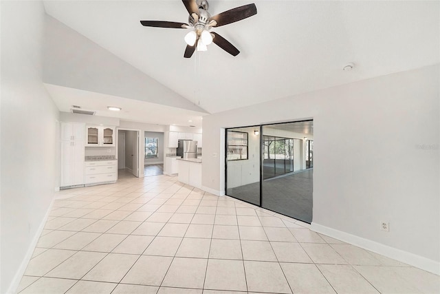 empty room with baseboards, ceiling fan, and a wealth of natural light