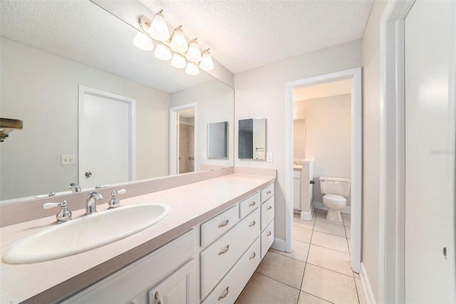 bathroom featuring tile patterned floors, vanity, toilet, and a textured ceiling