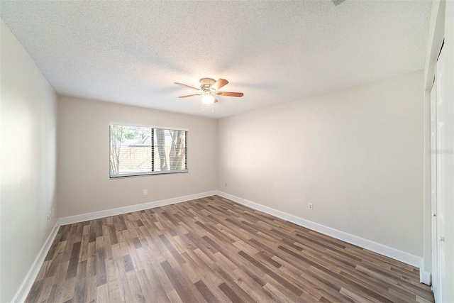 empty room with baseboards, a ceiling fan, a textured ceiling, and wood finished floors