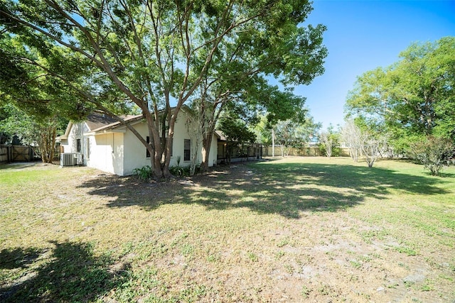 view of yard with a fenced backyard and central AC unit