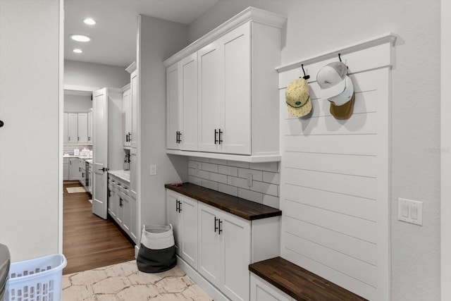 8717 SE 156th St, Summerfield, FL 34491 - kitchen with butcher block counters, backsplash, recessed lighting, and white cabinetry