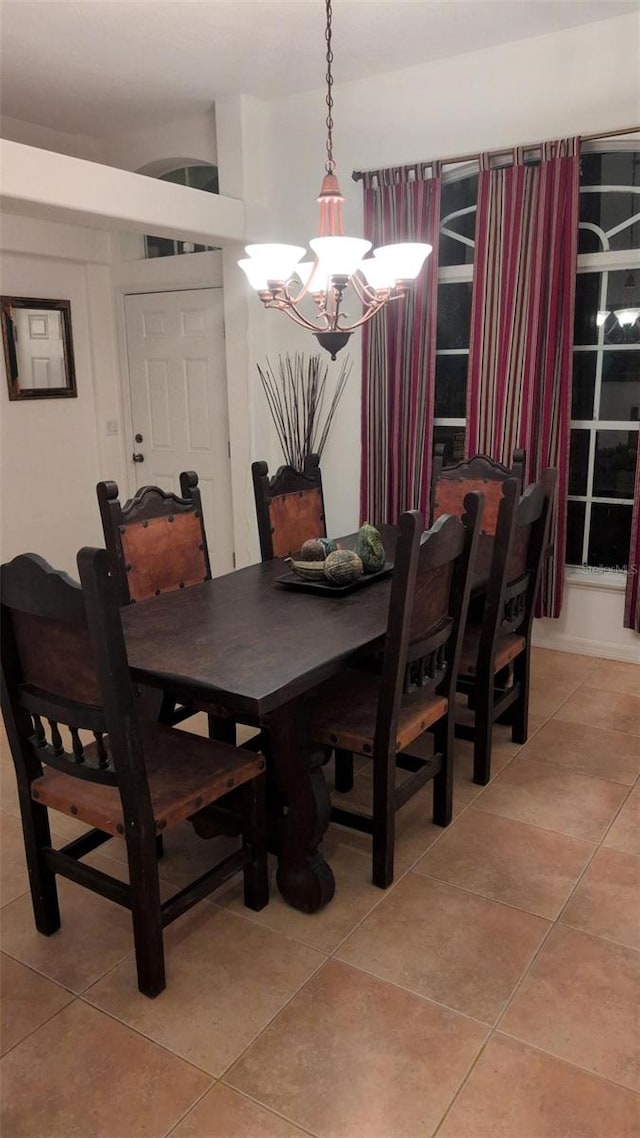 dining room with light tile patterned floors and a chandelier