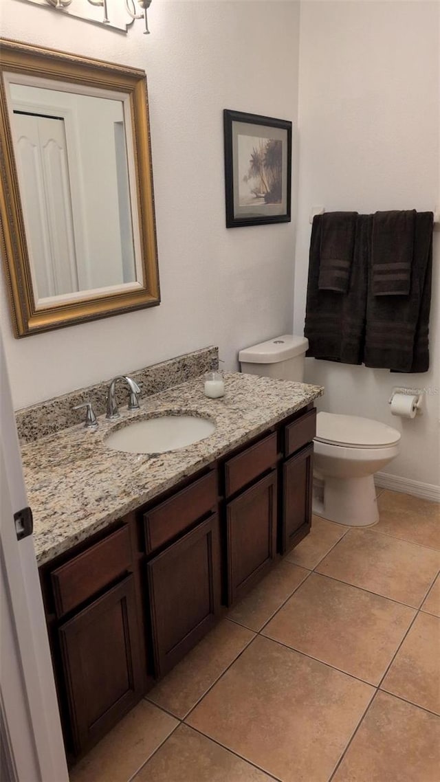 bathroom featuring tile patterned floors, baseboards, vanity, and toilet