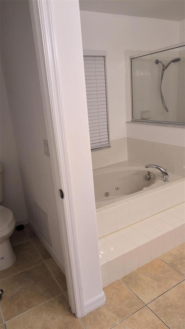full bath with toilet, tile patterned floors, visible vents, and a jetted tub