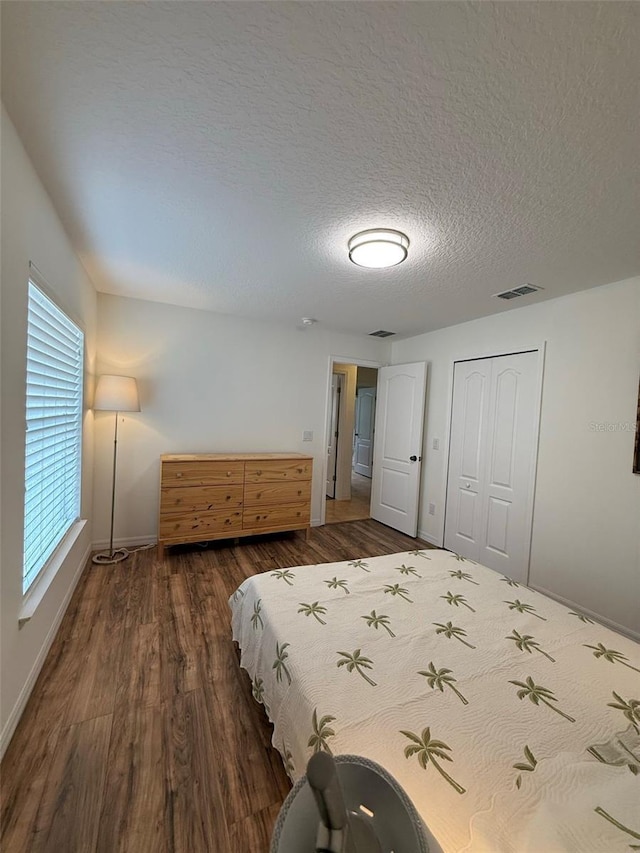 4920 E Lake Cove Blvd, Saint Cloud, FL 34771 - bedroom featuring dark wood-style flooring, baseboards, a closet, and a textured ceiling