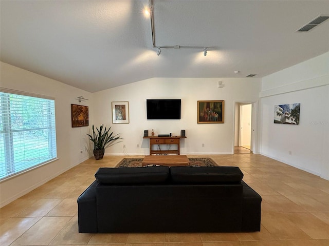4920 E Lake Cove Blvd, Saint Cloud, FL 34771 - living room featuring rail lighting, light tile patterned flooring, lofted ceiling, and baseboards