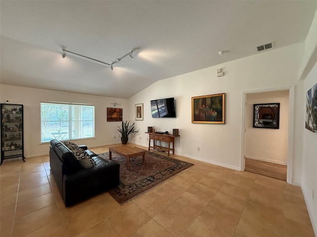 4920 E Lake Cove Blvd, Saint Cloud, FL 34771 - living area with rail lighting, lofted ceiling, light tile patterned floors, and baseboards
