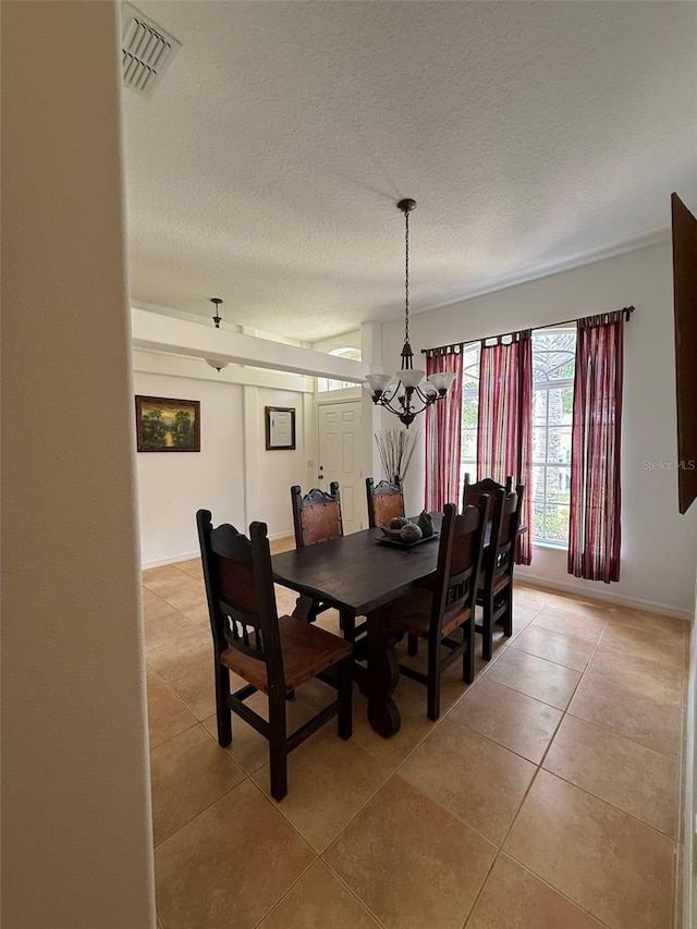 4920 E Lake Cove Blvd, Saint Cloud, FL 34771 - dining space featuring light tile patterned floors, a chandelier, a textured ceiling, and baseboards
