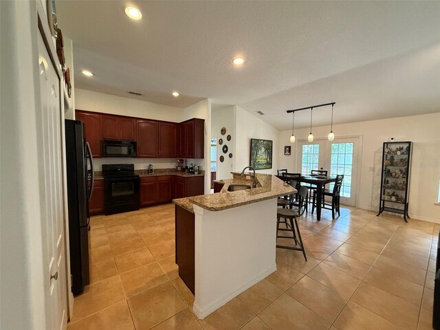 4920 E Lake Cove Blvd, Saint Cloud, FL 34771 - kitchen featuring black appliances, lofted ceiling, a kitchen breakfast bar, a sink, and recessed lighting