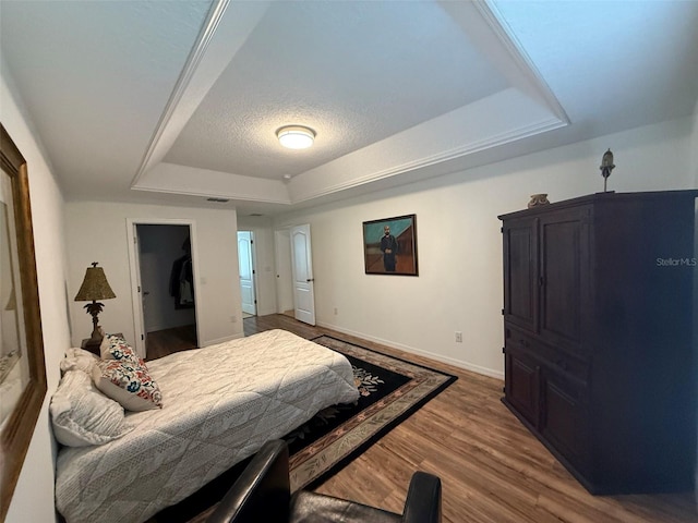 4920 E Lake Cove Blvd, Saint Cloud, FL 34771 - bedroom featuring a tray ceiling, baseboards, and wood finished floors